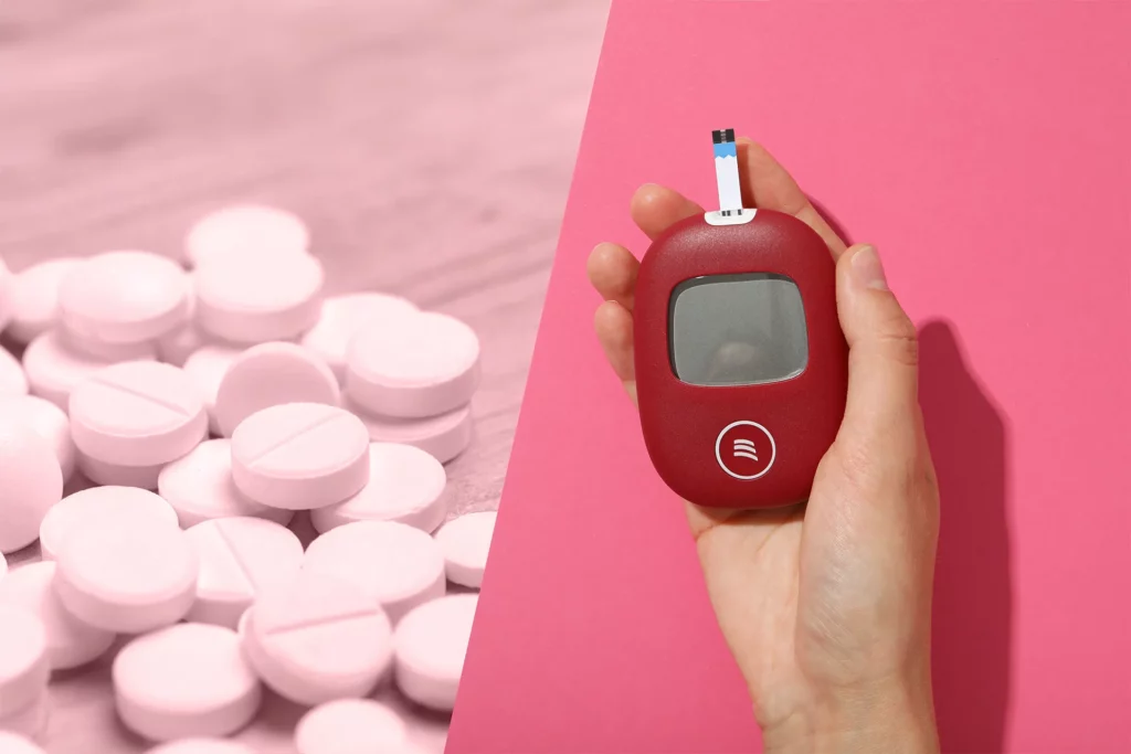 Metformin tablets alongside a red glucose meter on a pink background